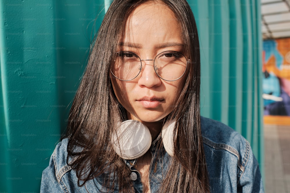Portrait of an asian girl wearing glasses and looking straight at the camera.