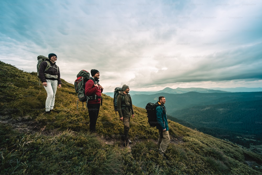 I quattro escursionisti con gli zaini in piedi sulla montagna