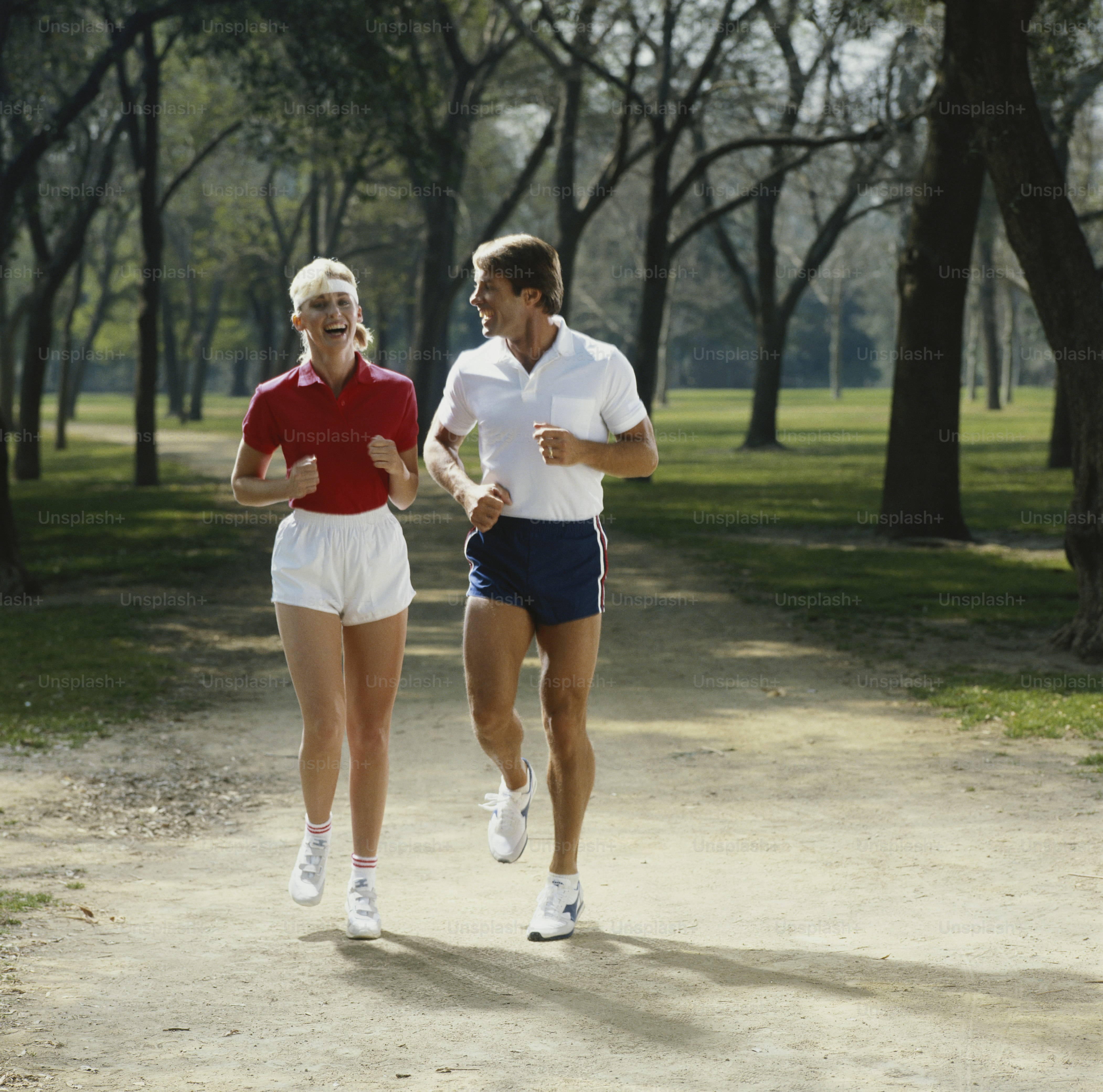 Un homme et une femme courant dans un parc