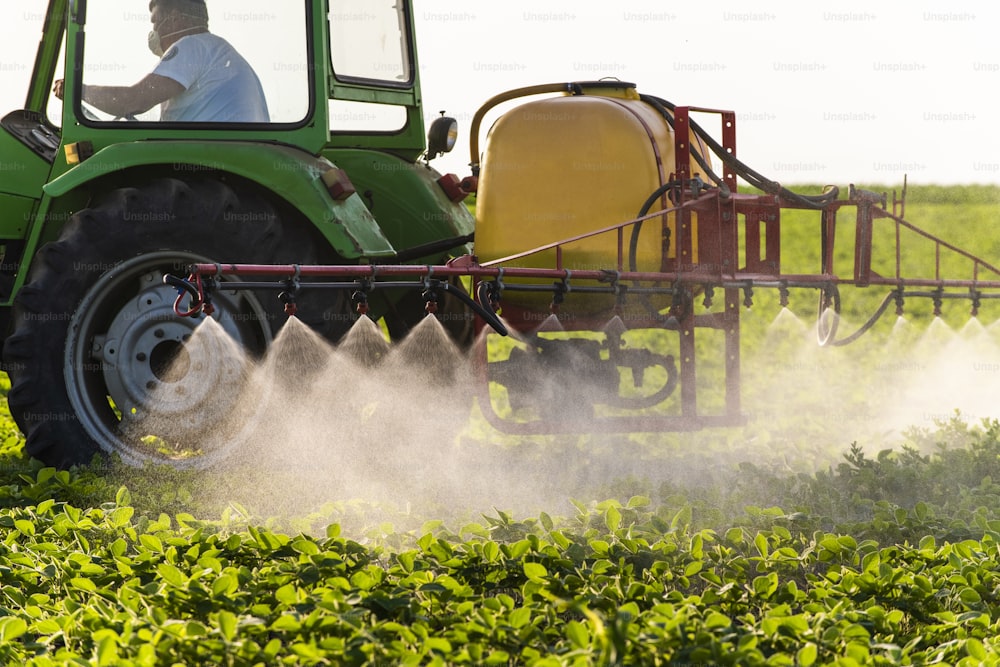 Traktor sprüht Pestizide auf Sojafeld mit Sprühgerät im Frühjahr
