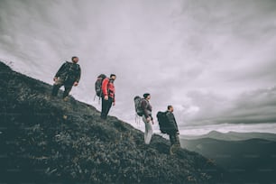 Le quattro persone con gli zaini in piedi sulla montagna