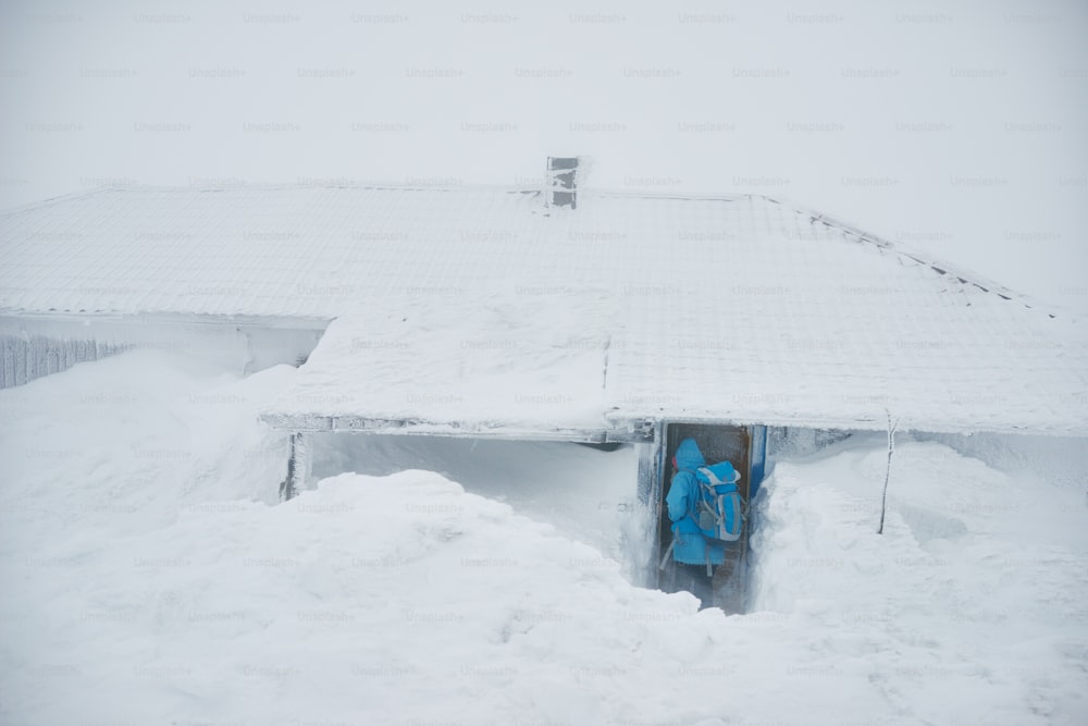 Woman entering snowy house