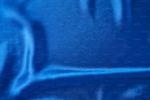 Fundo de seda azul com dobras.  Textura abstrata da superfície de cetim ondulado
