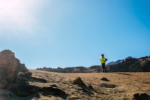 でアウトドアレジャーを楽しむ立っている女性。山。アクティブ・ヘルシー・ライフスタイル・エクスペディション - スポーツ・ハイキング・アクティブ・ライフのオルタナティブ・ピープル - 砂漠の孤独な旅人
