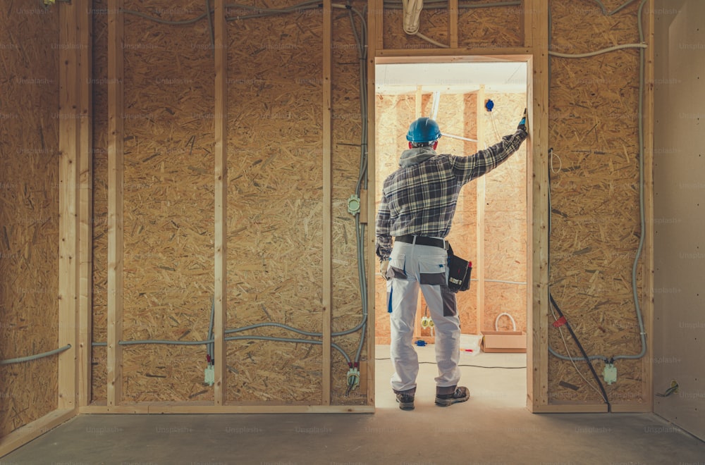 Construction Electric Contractor Wearing Hard Hat Building Electrical System. Industrial Theme.