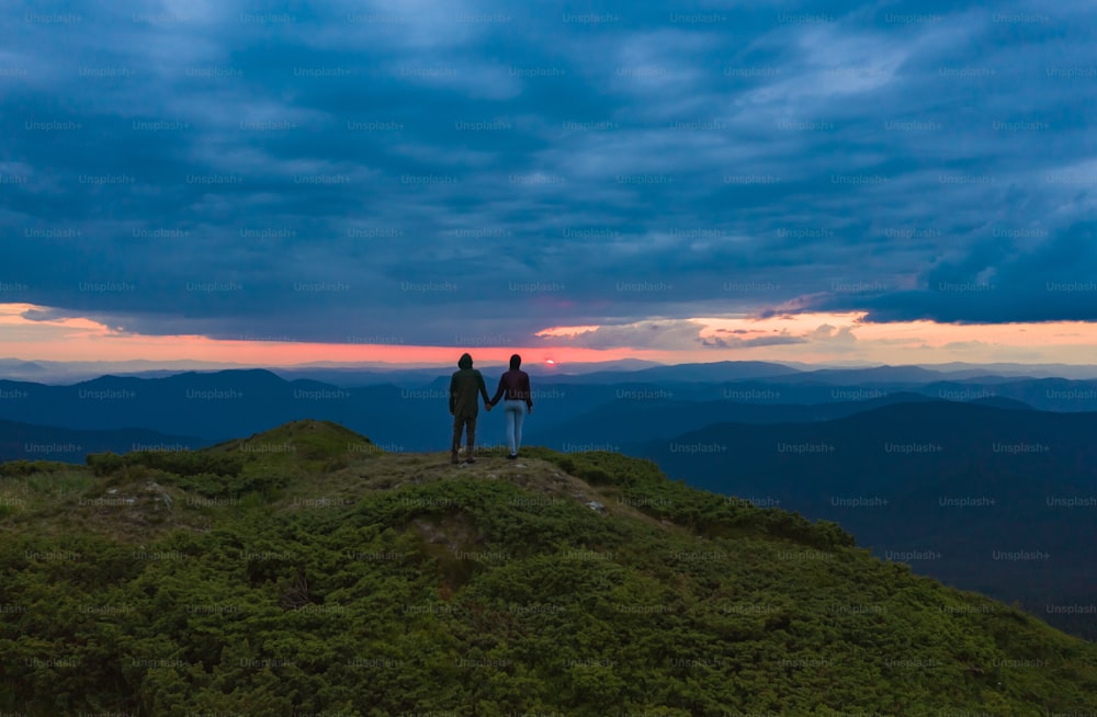 The couple standing on the beautiful sunset background