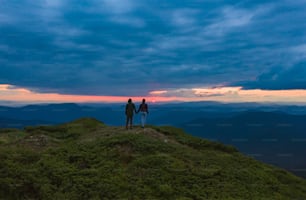 The couple standing on the beautiful sunset background