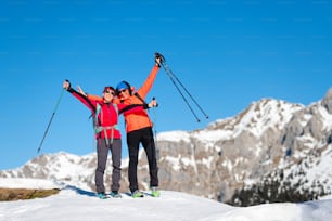 Two climbers conquer the top of a mountain