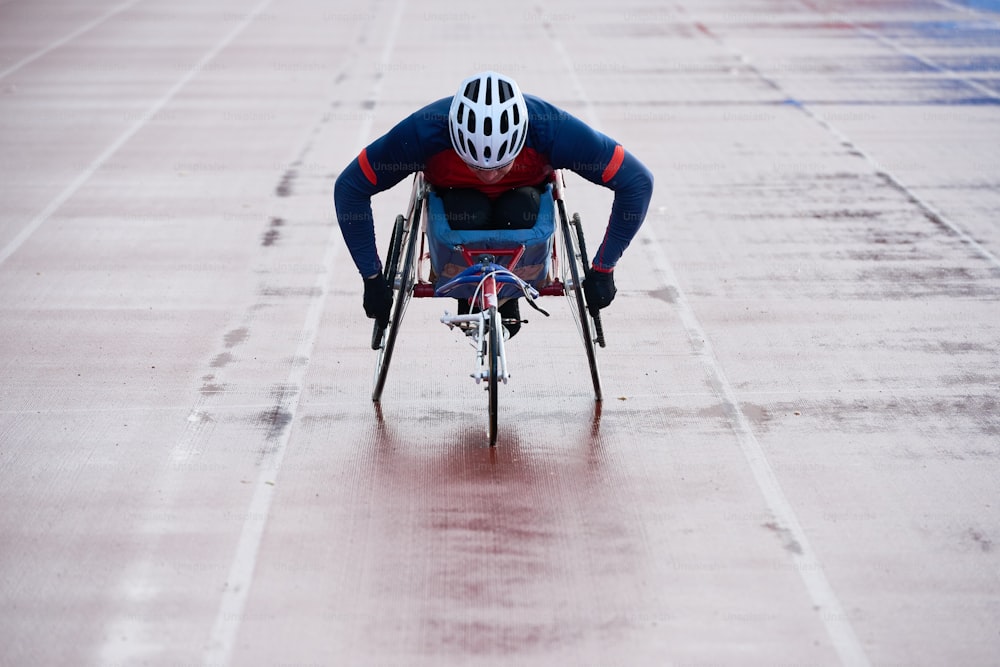Creating records in wheelchair. Physically impaired male athlete coming towards finish while racing in sport wheelchair on outdoor track