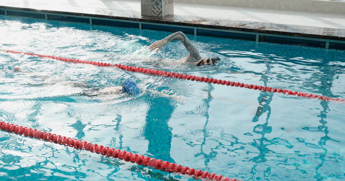 Swimmers racing against each other while training together in swimming ...