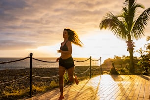 Schöne Dame läuft mit Sonnenuntergang in Background - gesunder Lebensstil Konzept Menschen