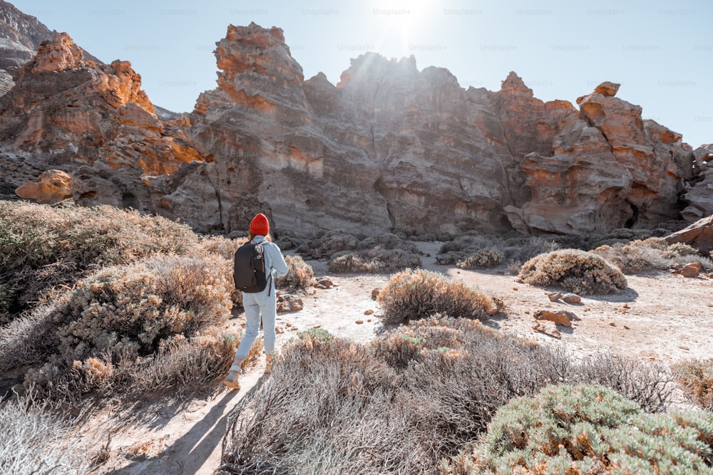 Paisagem de uma bela rocha no vale do deserto com a mulher que viaja no parque natural perto do vulcão Teide na ilha de Tenerife, Spain