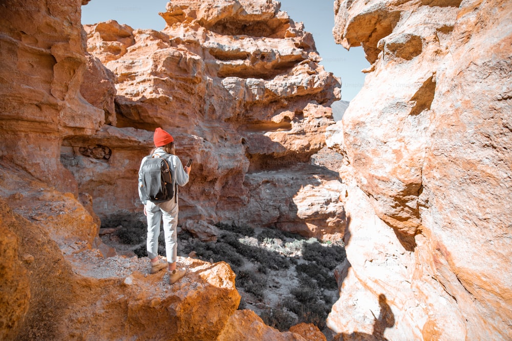 Viaggiatrice che gode di splendidi paesaggi in piedi tra le enormi rocce di origine vulcanica in una giornata di sole. Viaggiare sull'isola di Tenerife, Spagna