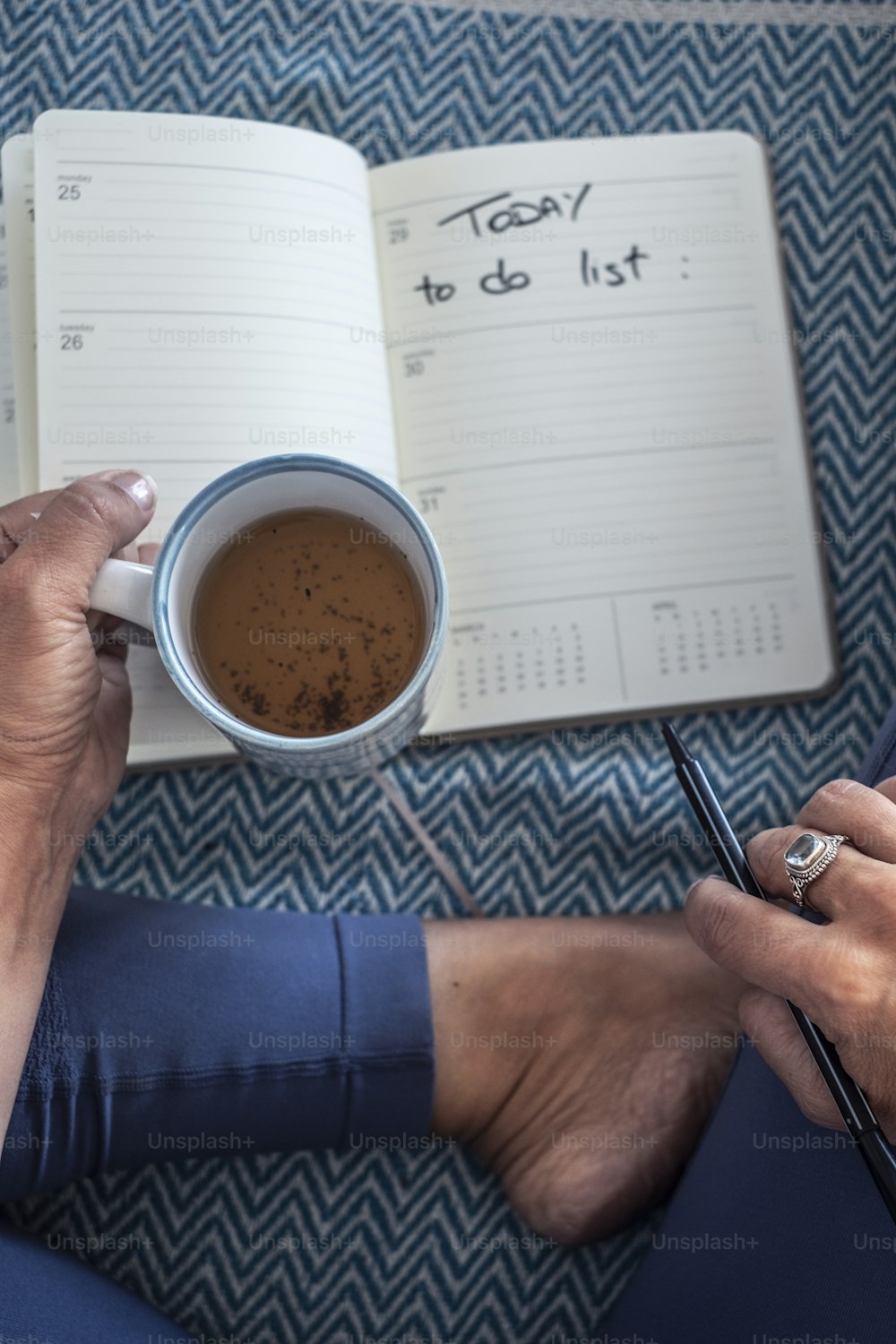 Concept of quarantine stay at home for coronavirus health emergency  - above view of woman with notes and pen writing to do daily list drinking a cup of tea - people planning the day indoor