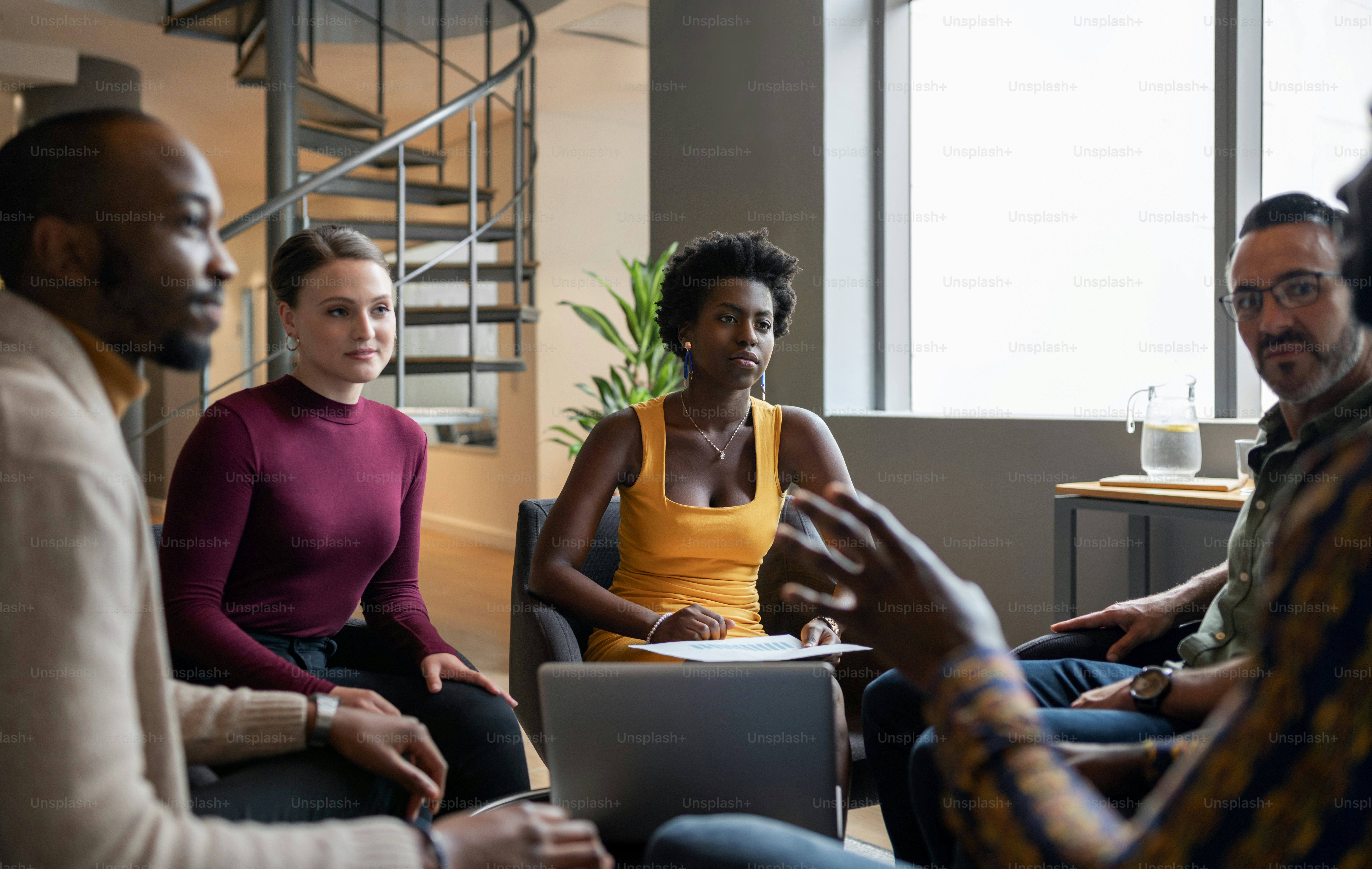 Team of diverse businesspeople having a casual meeting together in the lounge area of an office