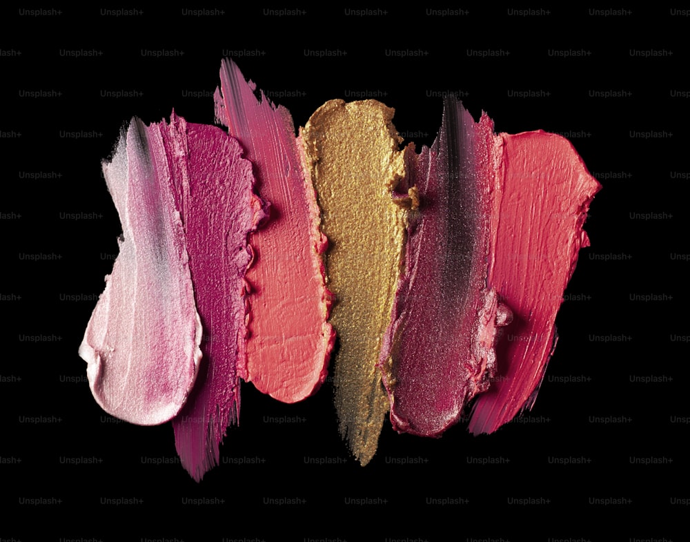 Smudged red purple mustard yellow pink textured tint or lipstick on white and multi-colored background