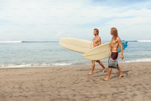 Surfing. Handsome Surfers With Surfboards. Young Men Walking On Sandy Beach. Active Lifestyle, Water Sport On Beautiful Ocean Background.