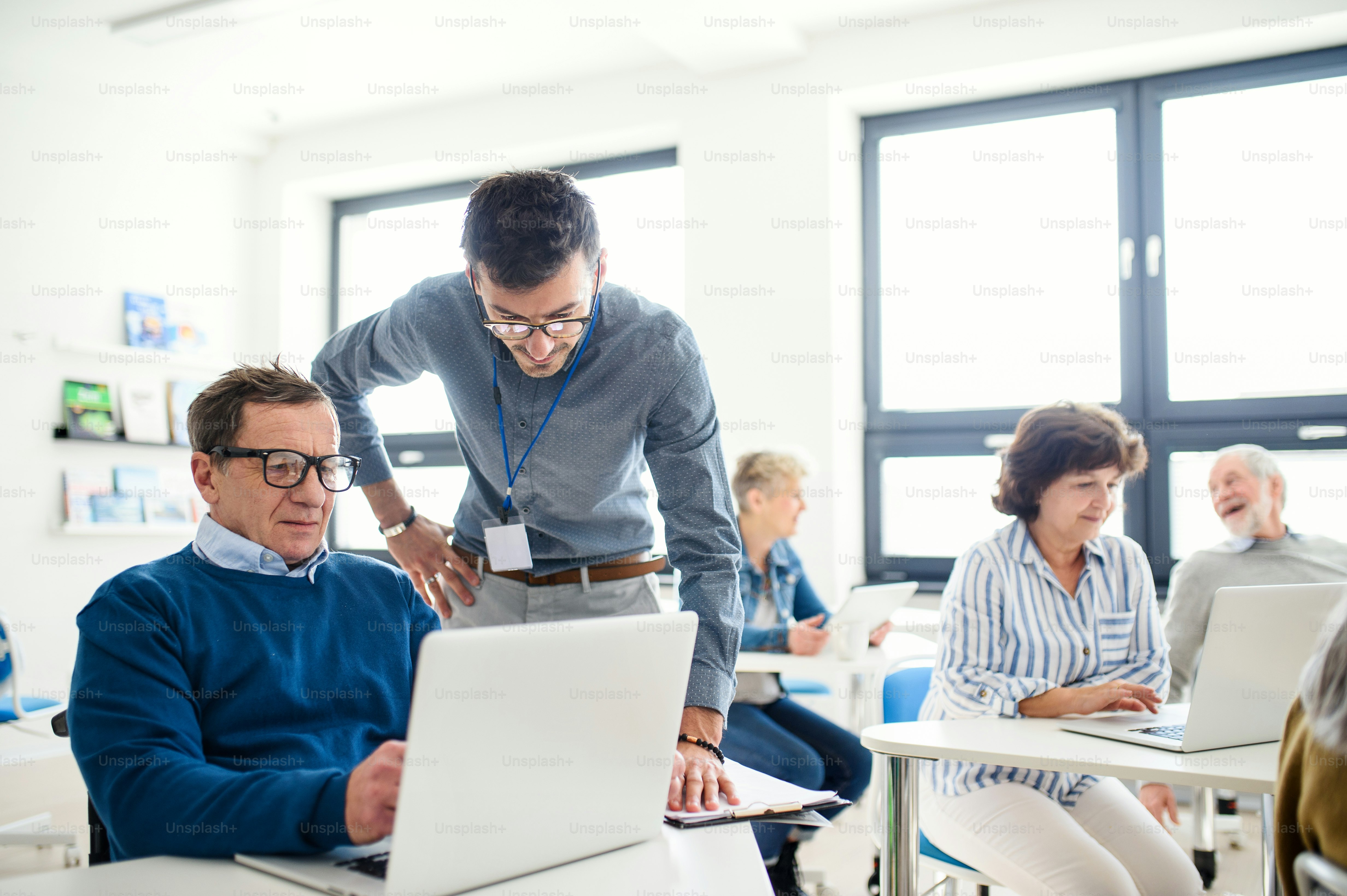 Grupo de alegres personas mayores que asisten a la clase de educación informática y tecnológica
