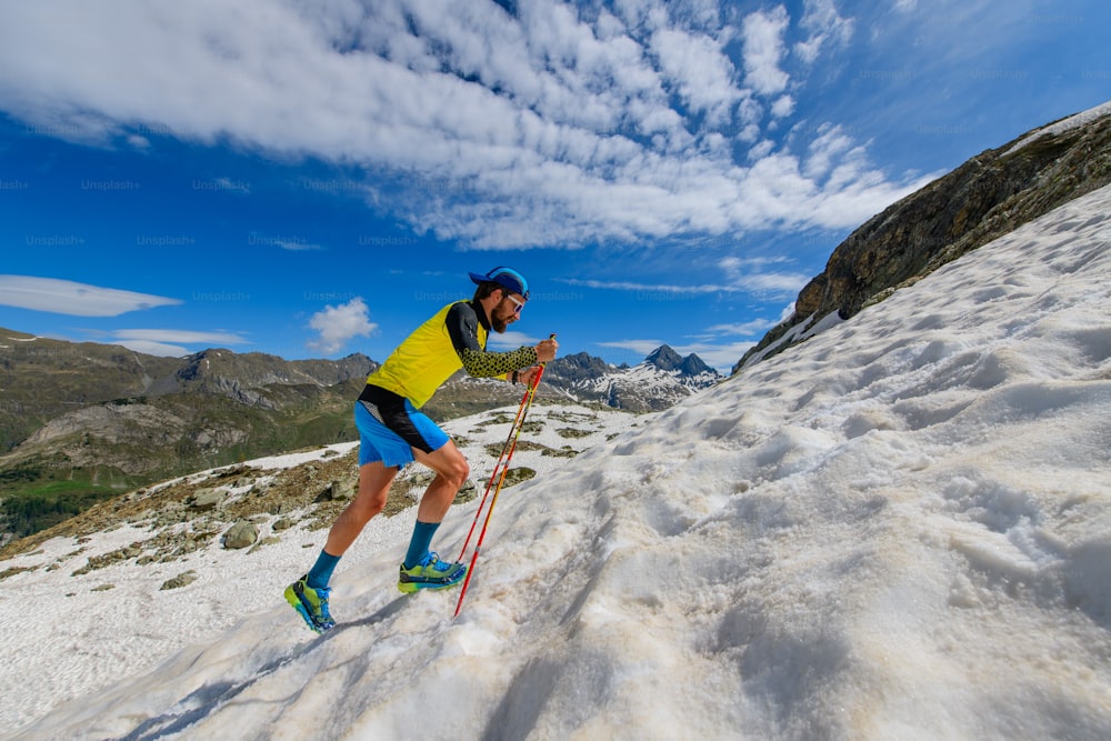 Skyrunner runner uphill in a snowy stretch