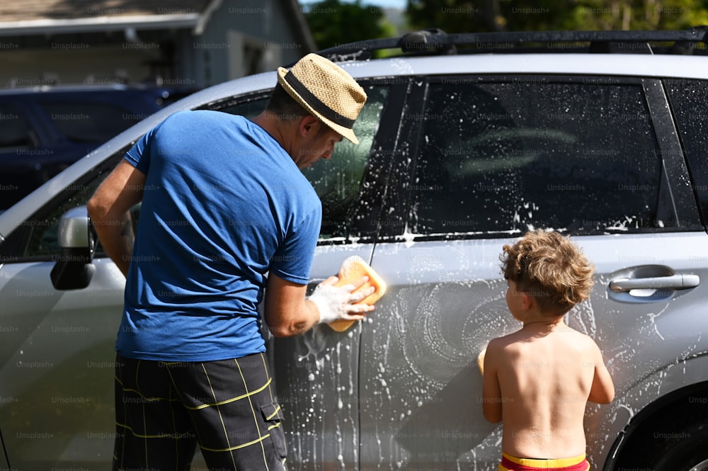 um homem e um menino estão lavando um carro
