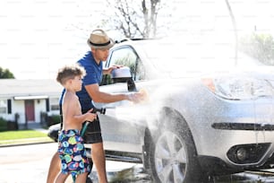 a man and a boy are washing a car