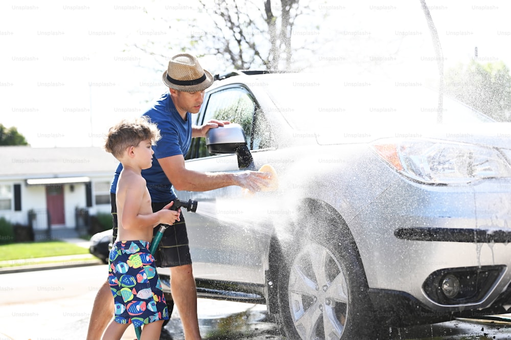 Un hombre y un niño están lavando un coche