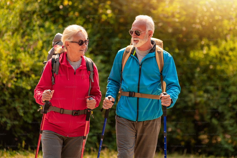 Senior couple walking in nature with backpacks.Nature,leisure time and lifestyle concept.