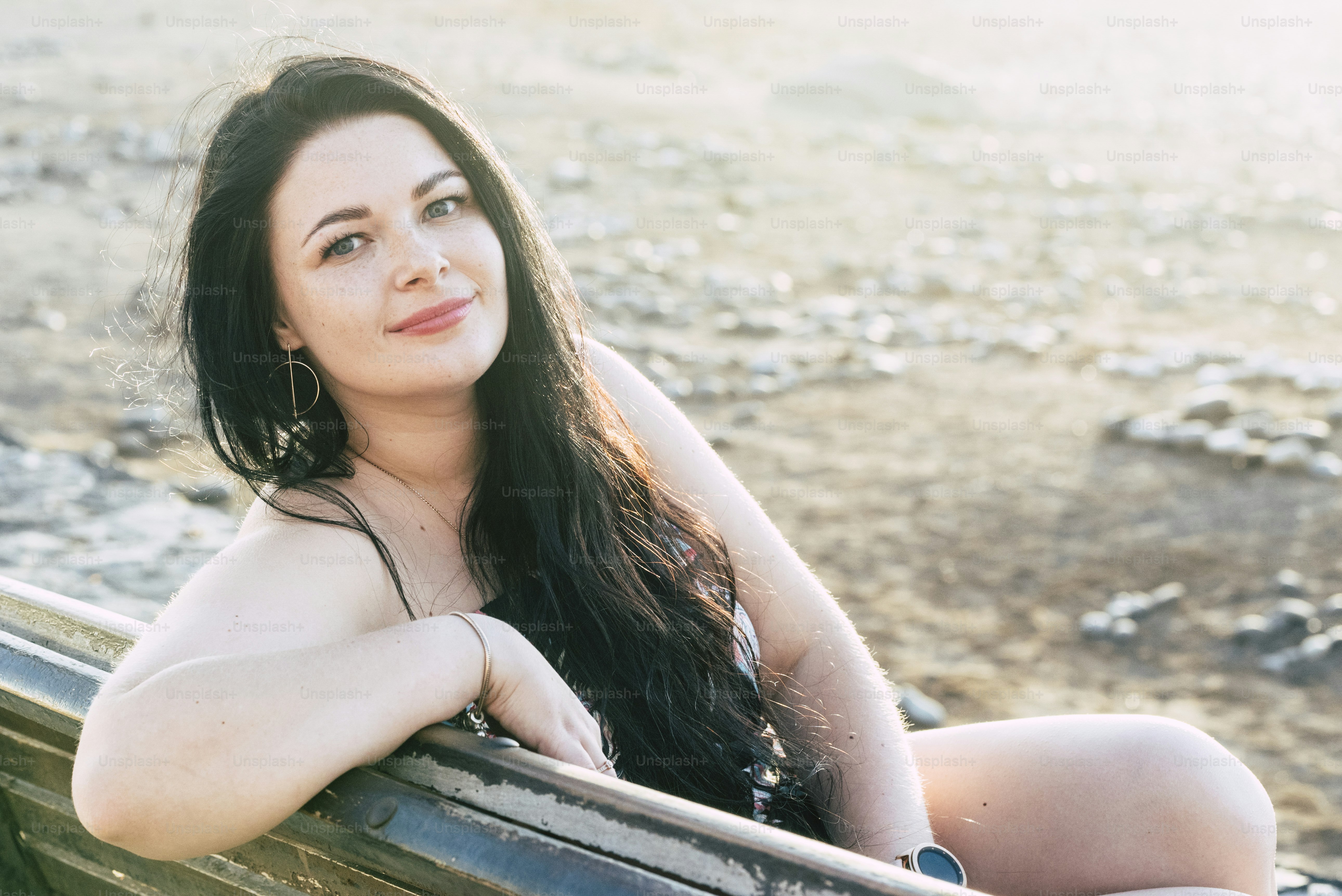 Portrait of beautiful young caucasian girls sitting on a bench in outdoor