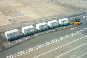 Carrelli portabagagli vuoti in aeroporto, per scaricare i bagagli degli aerei passeggeri, in mezzo alle code degli aerei