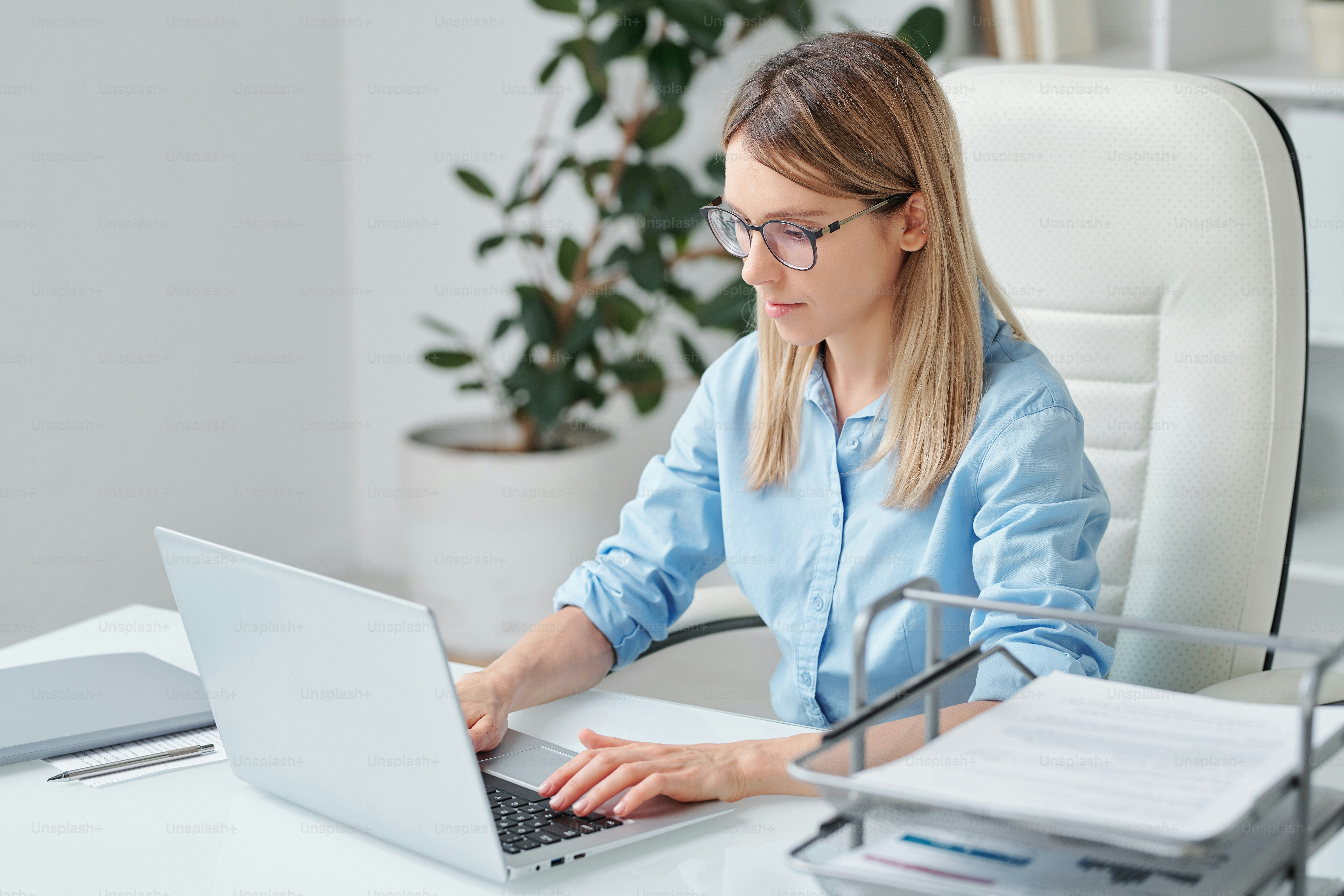 Busy young elegant secretary or accountant reading financial paper and ...