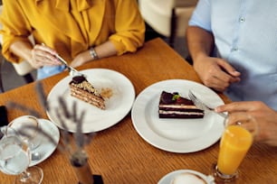 カフェでデザートにケーキを食べるカップルのクローズアップ。