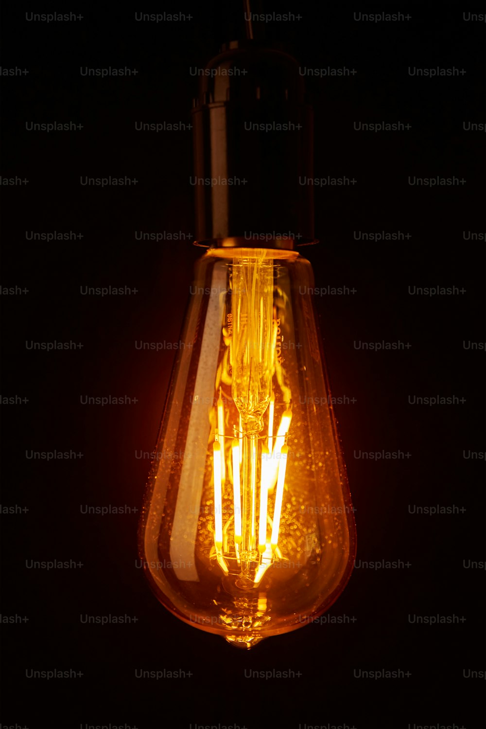Lampadina dell'annata su sfondo nero, primo piano Lampadina di Edison incandescente