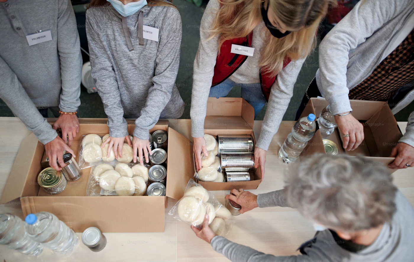Volunteers loading food donation boxes into a van at night