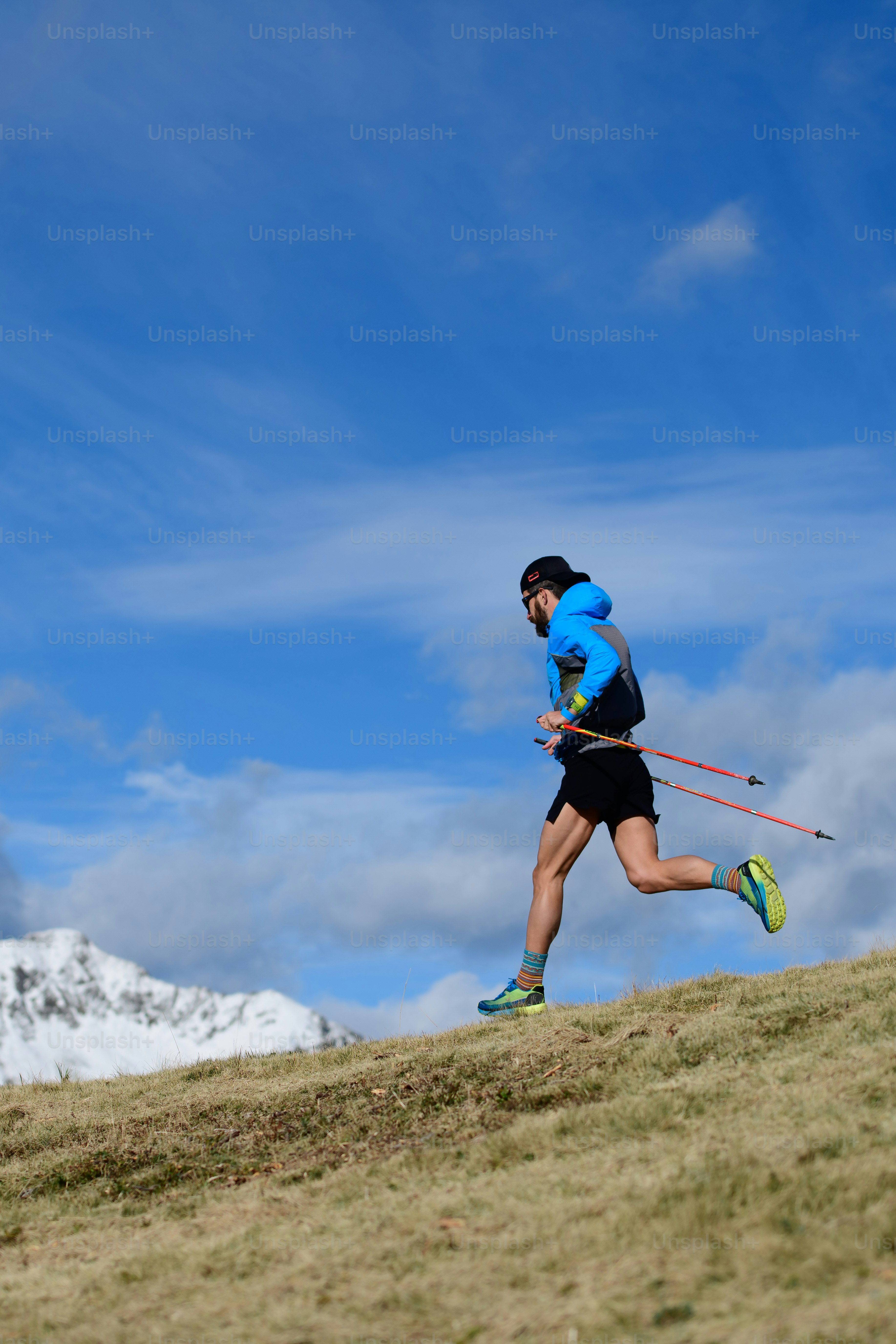 한 남자가 산에 첫 눈이 내리는 가을에 산에서 울트라 런 트레일을 위해 훈련합니다.