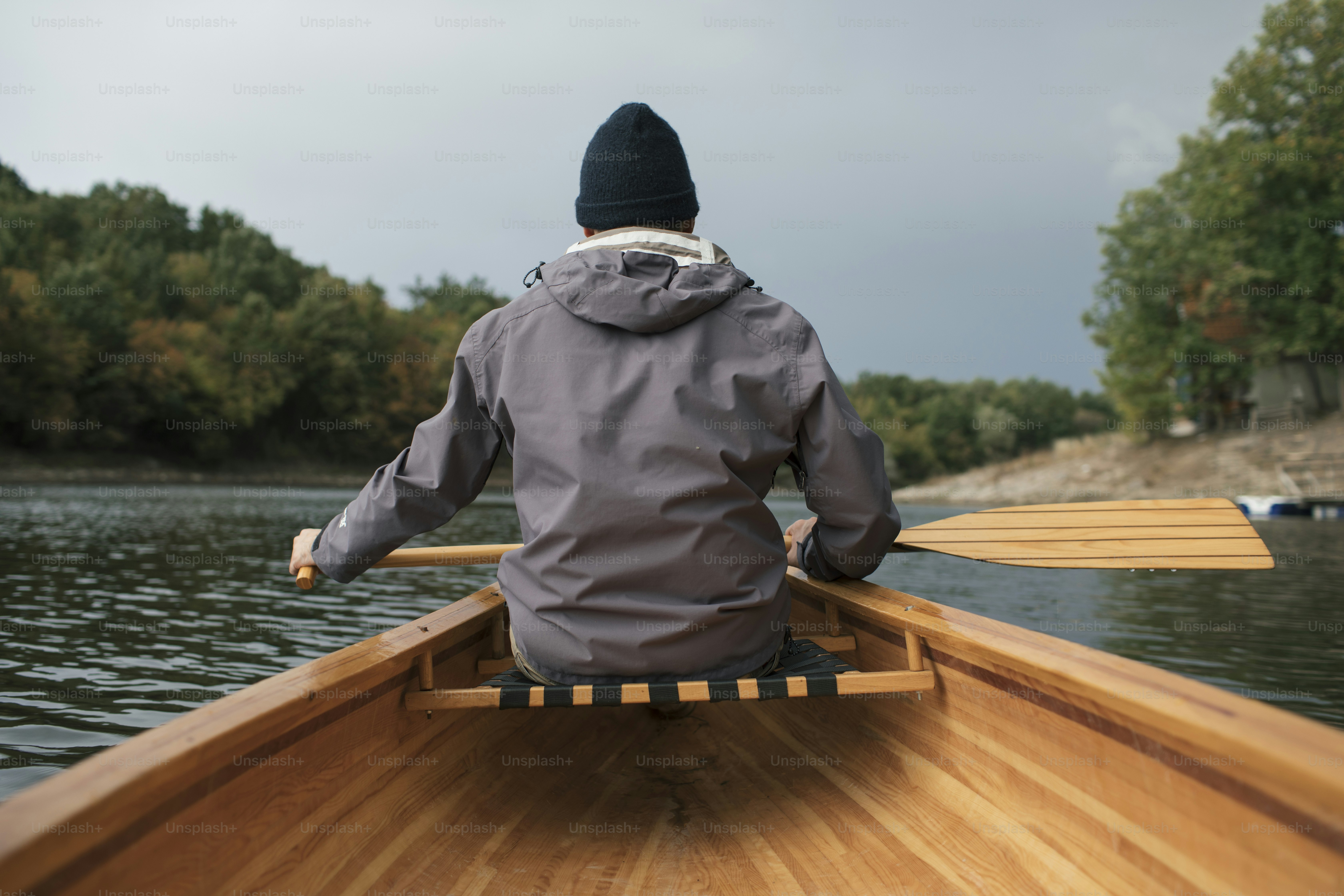 Rear view of man paddling canoe in the lake forest. photo – Oar Image ...