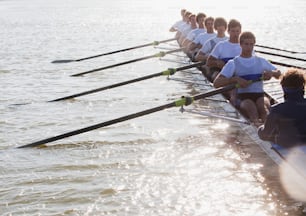 a row of rowers sitting on the side of a boat