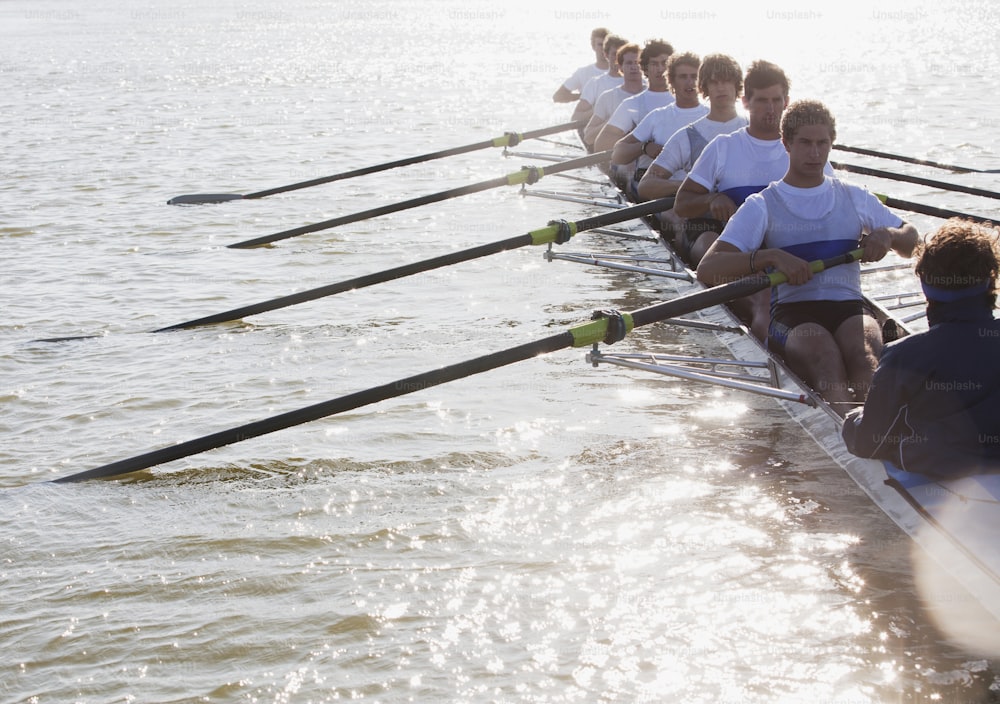a row of rowers sitting on the side of a boat