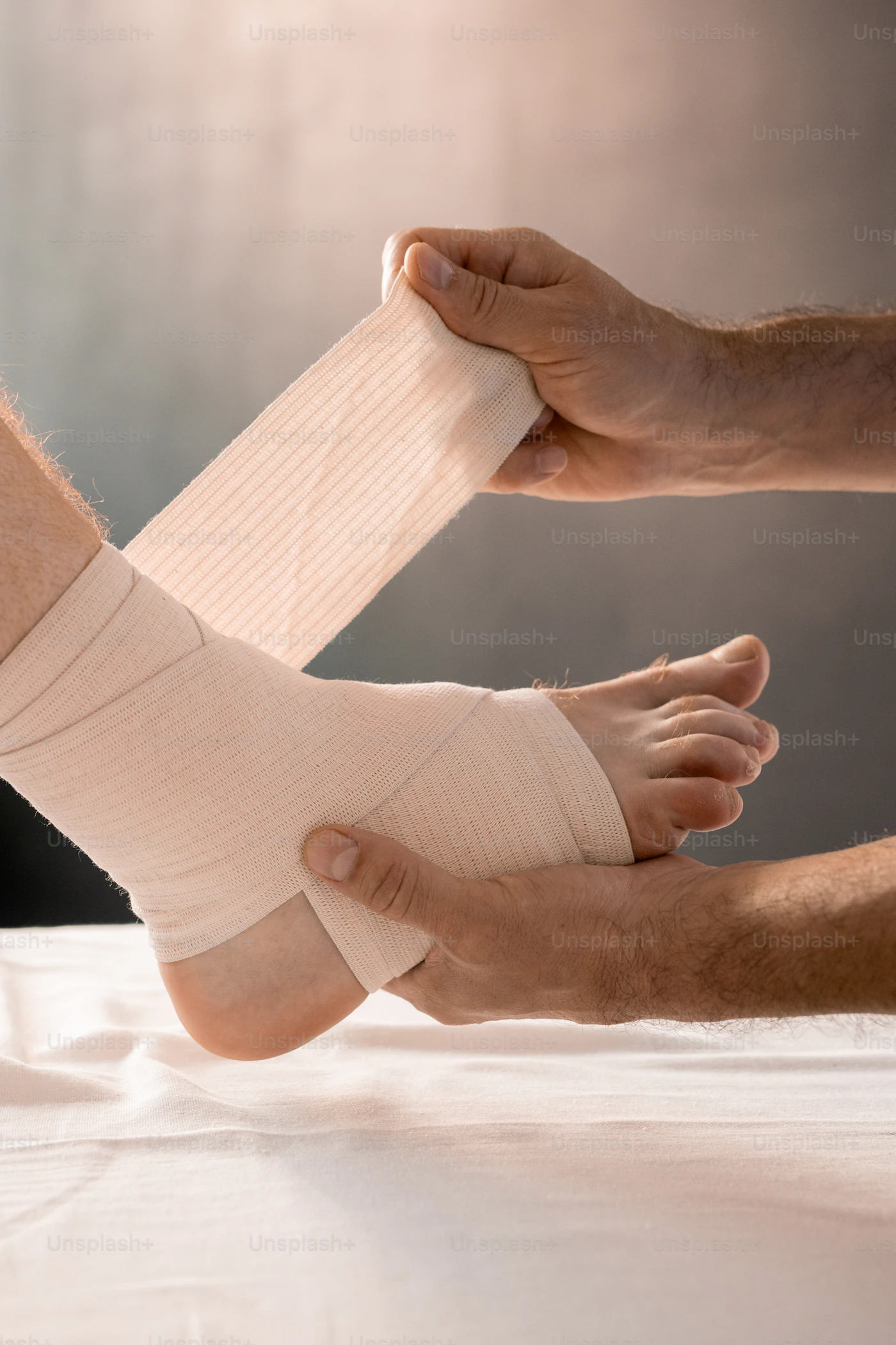 Clinician wrapping an elastic bandage around a patient's foot and ankle