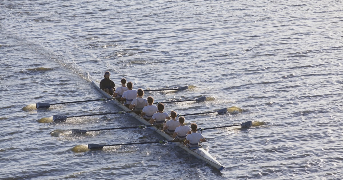 A group of people rowing a boat on a body of water photo – Water Image ...