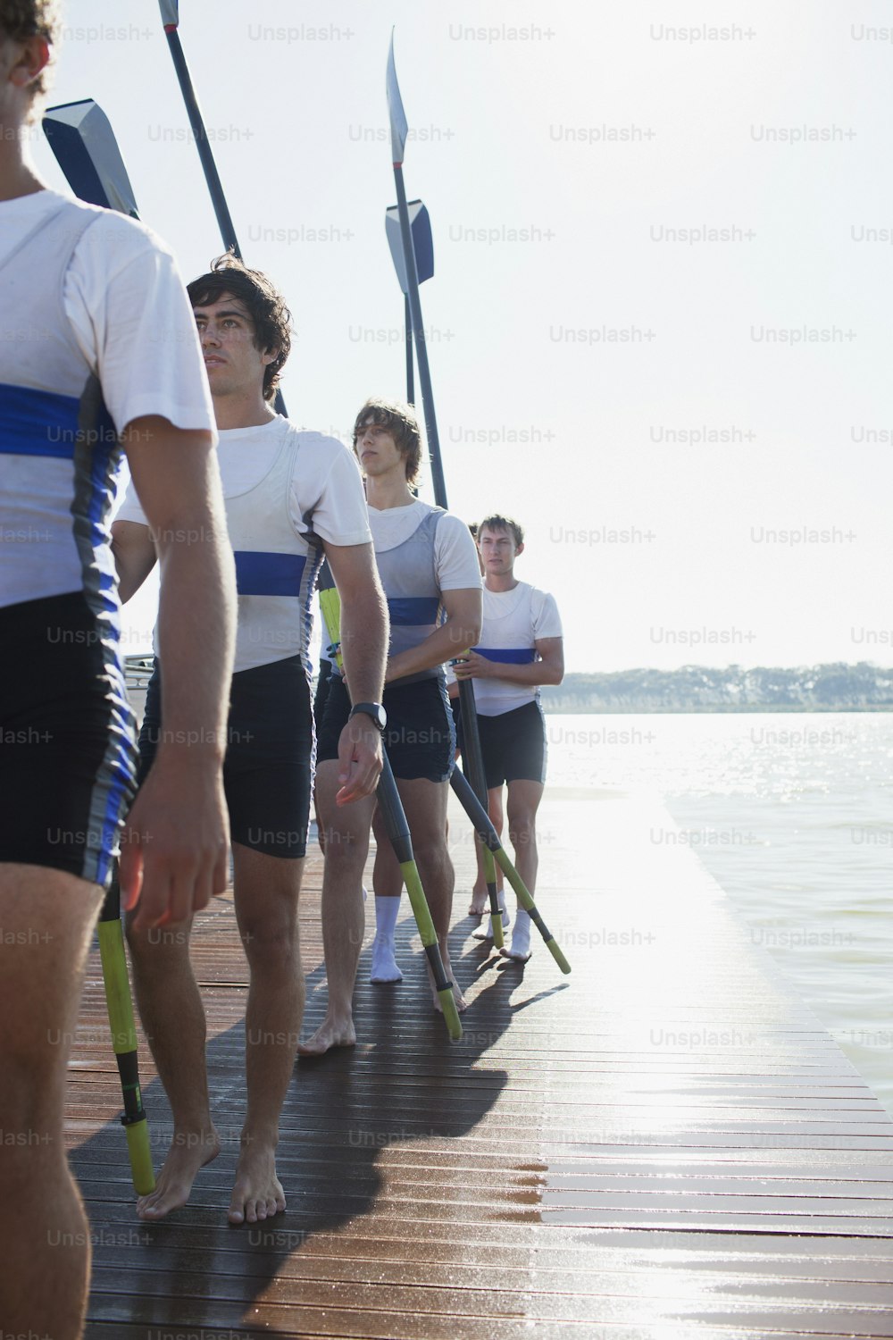 a group of men standing on top of a wooden pier