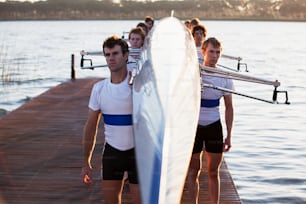 a group of men standing next to each other near a body of water