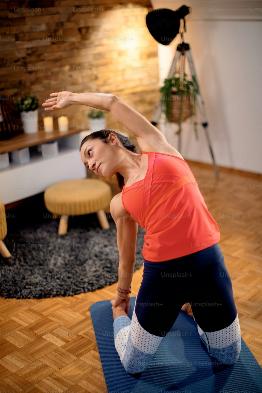 Athletic woman warming up and stretching while exercising at home.