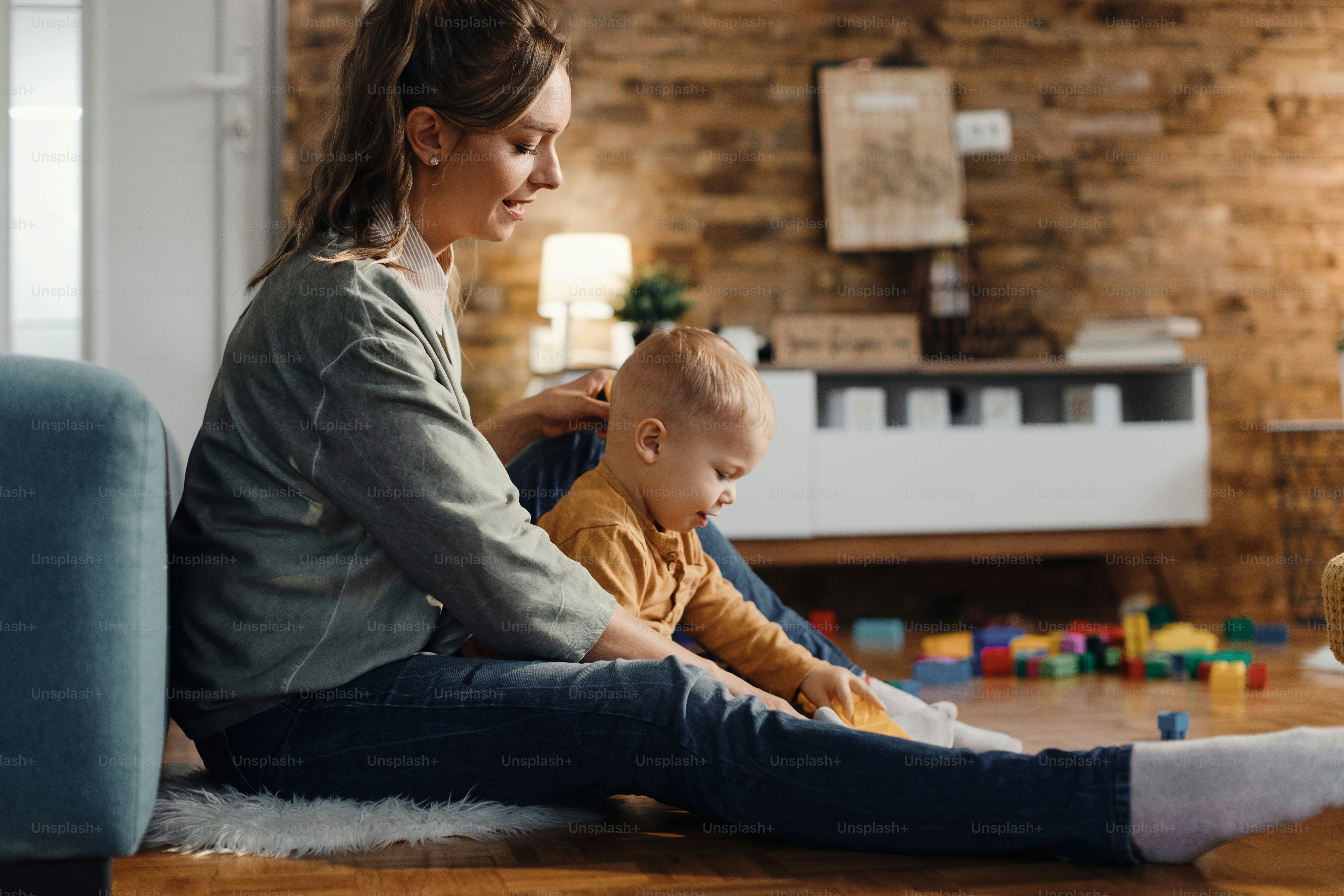 Side view of happy mother and her small son playing in the living room.