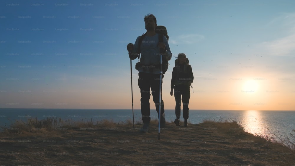 Le due persone che camminano sullo sfondo del paesaggio marino
