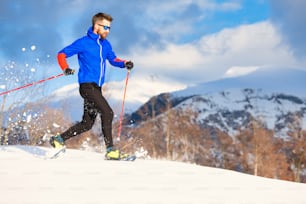 Um atleta homem treina para correr com raquetes de neve