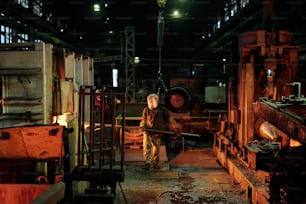 Gruppe von Arbeitern, die in der Fabrik mit Metall arbeiten