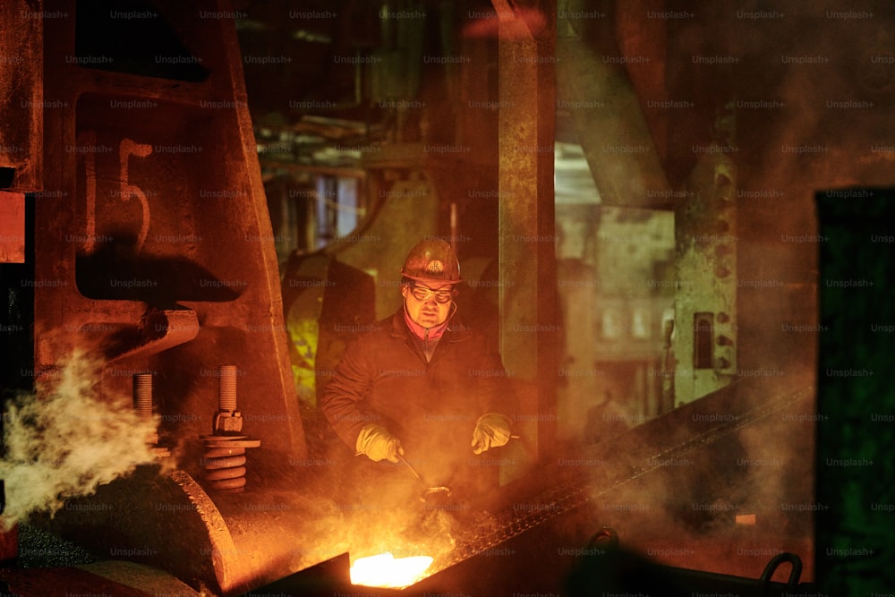 Worker in protective workwear operating at the metallurgical plant