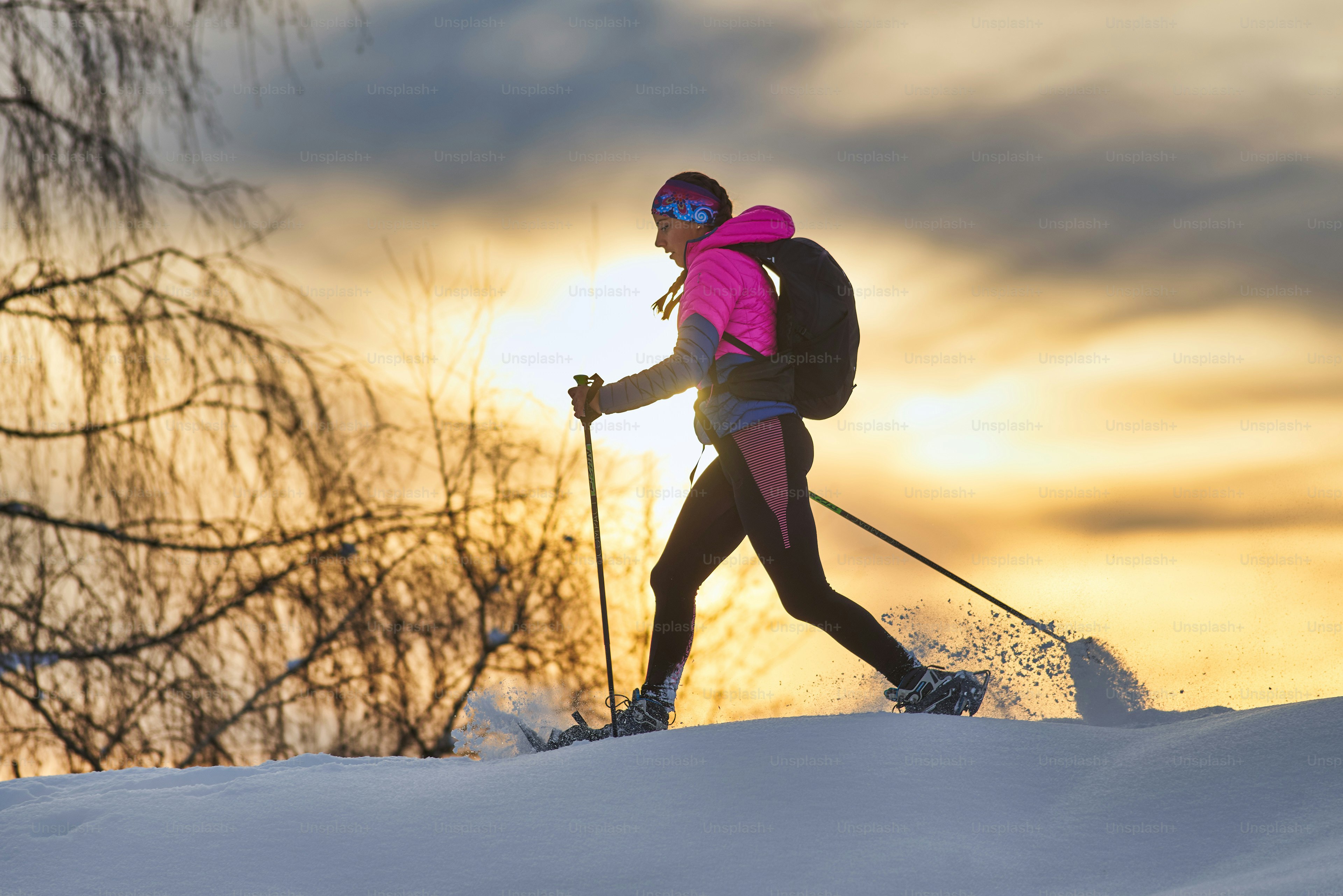 Lonely girl hike with snowshoes at sunset