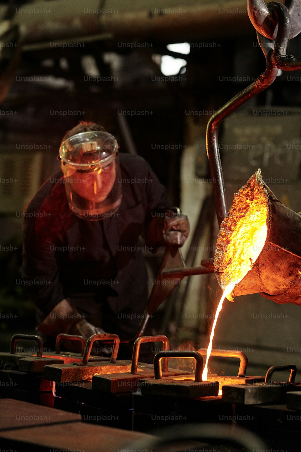 공장에서 철을 녹이는 보호 마�스크의 수동 작업자