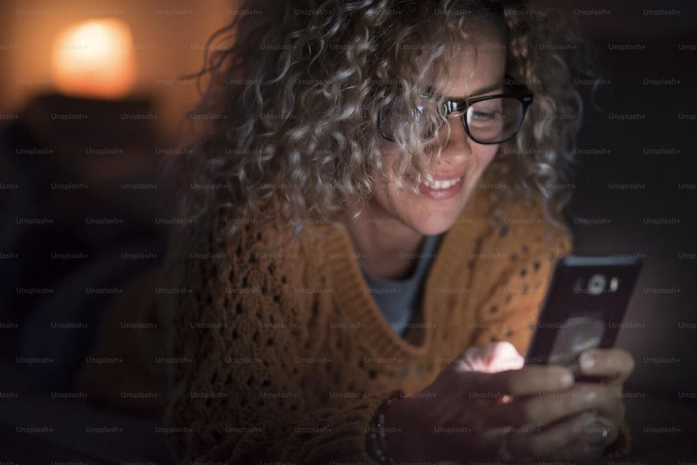 성인 여성은 집에서 혼자 밤에 인터넷 휴대 전화를 사용합니다 - 사람과 기술 중독 - 연결 및 전화 회의 개념 - 안경으로 웹 여성 검색